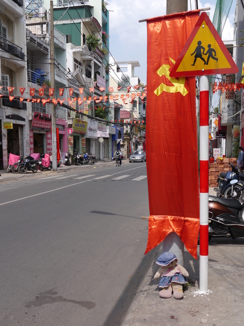 Somewhere in Saigon: Doll waiting to cross the road. Or celebrating Reunification day, not sure...