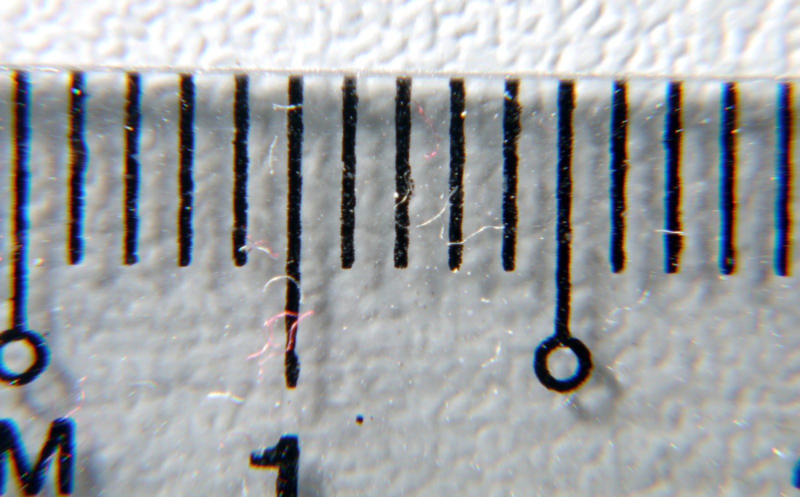 Picture of a ruler. Here, you see about 15mm of the ruler, so the magnification is 17.3:15 = 1:0.87 or 1.15x. Note the chromatic aberrations on the side of the image, but more on that later...